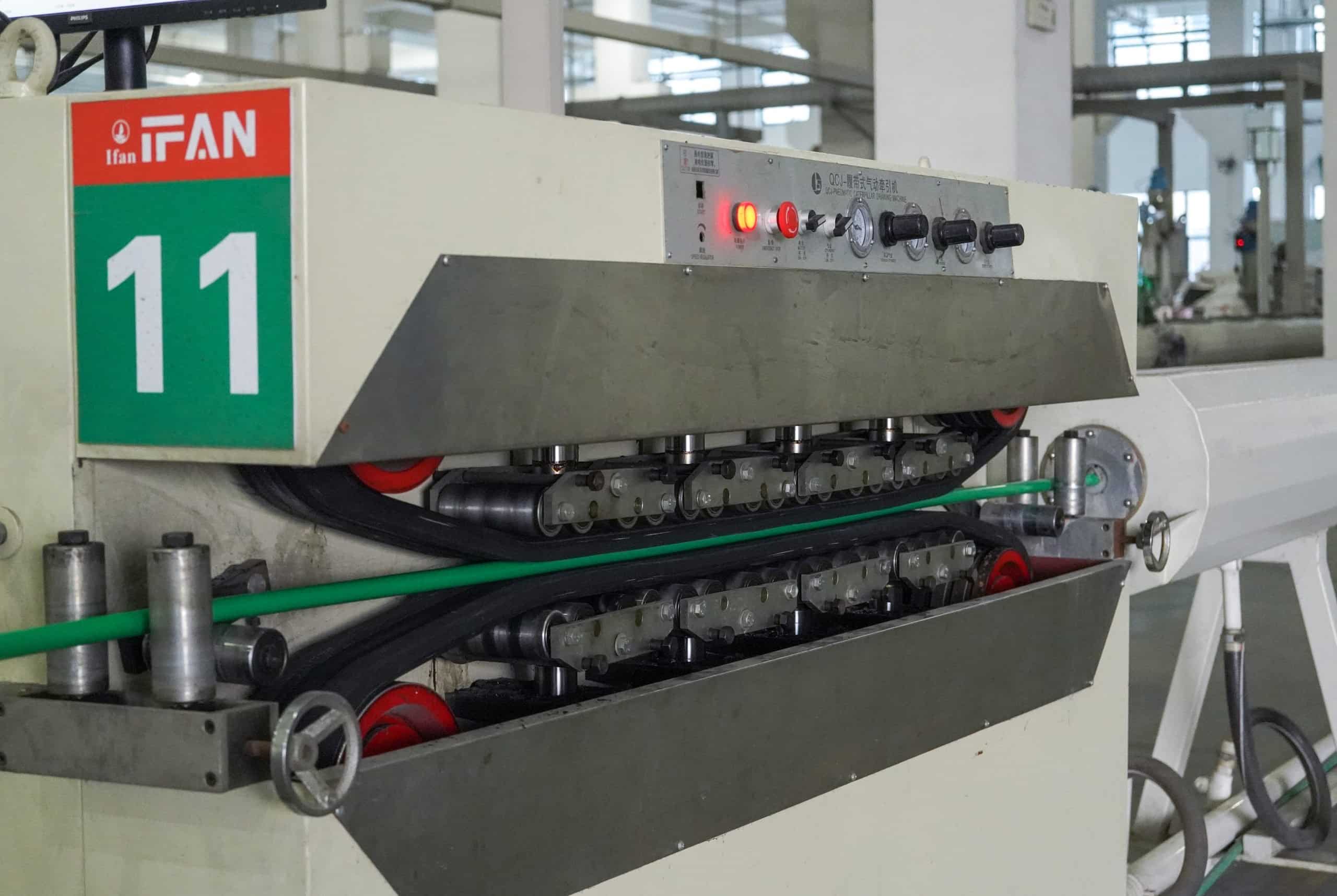 Green PP-R pipe running through the caterpillar haul-off of extrusion line 11 in the IFAN ULTRA pipe hall