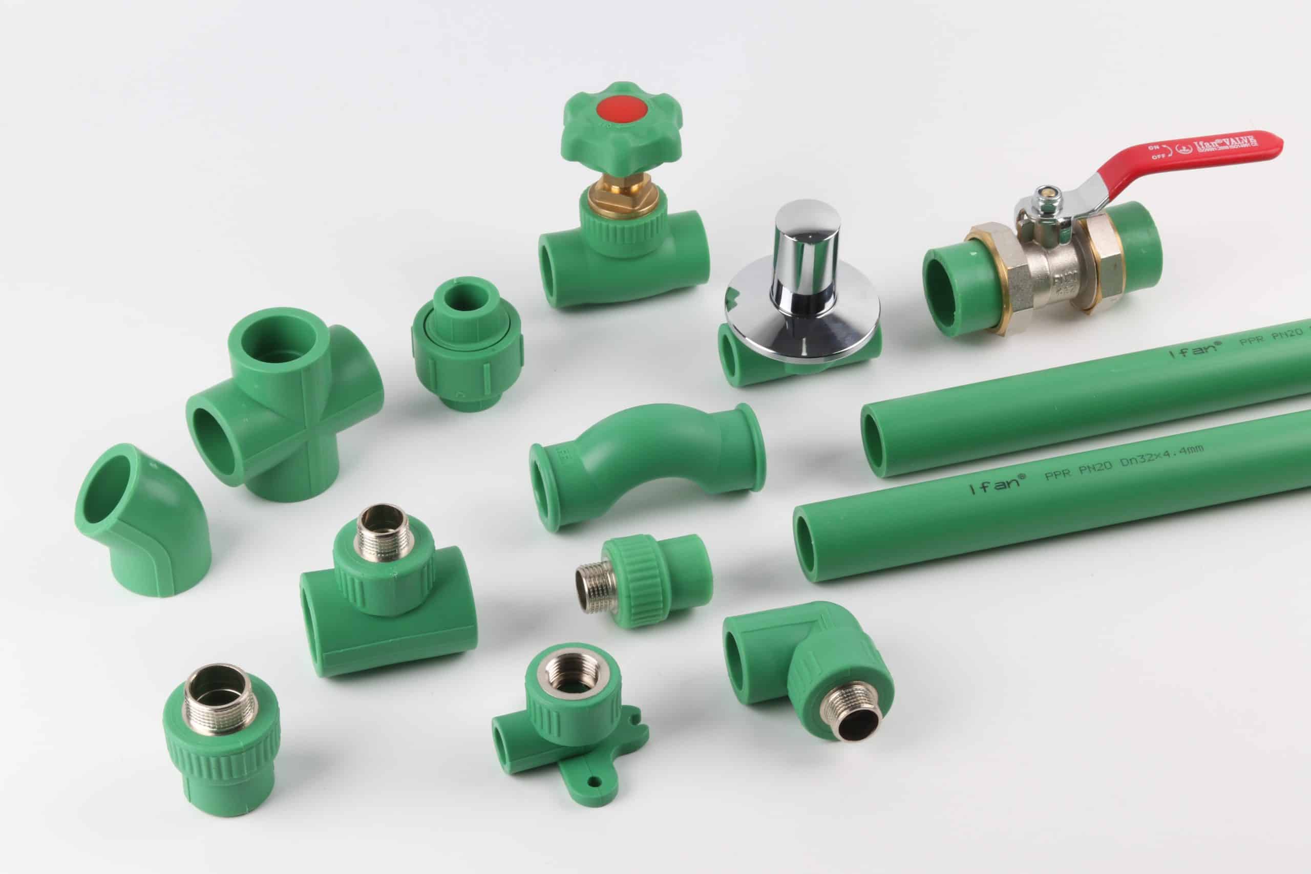 An IFANULTRA PP-R range laid out together: cross, elbows, tees, sockets, threaded adaptors, a stop valve, a ball valve and two lengths of green PP-R pipe