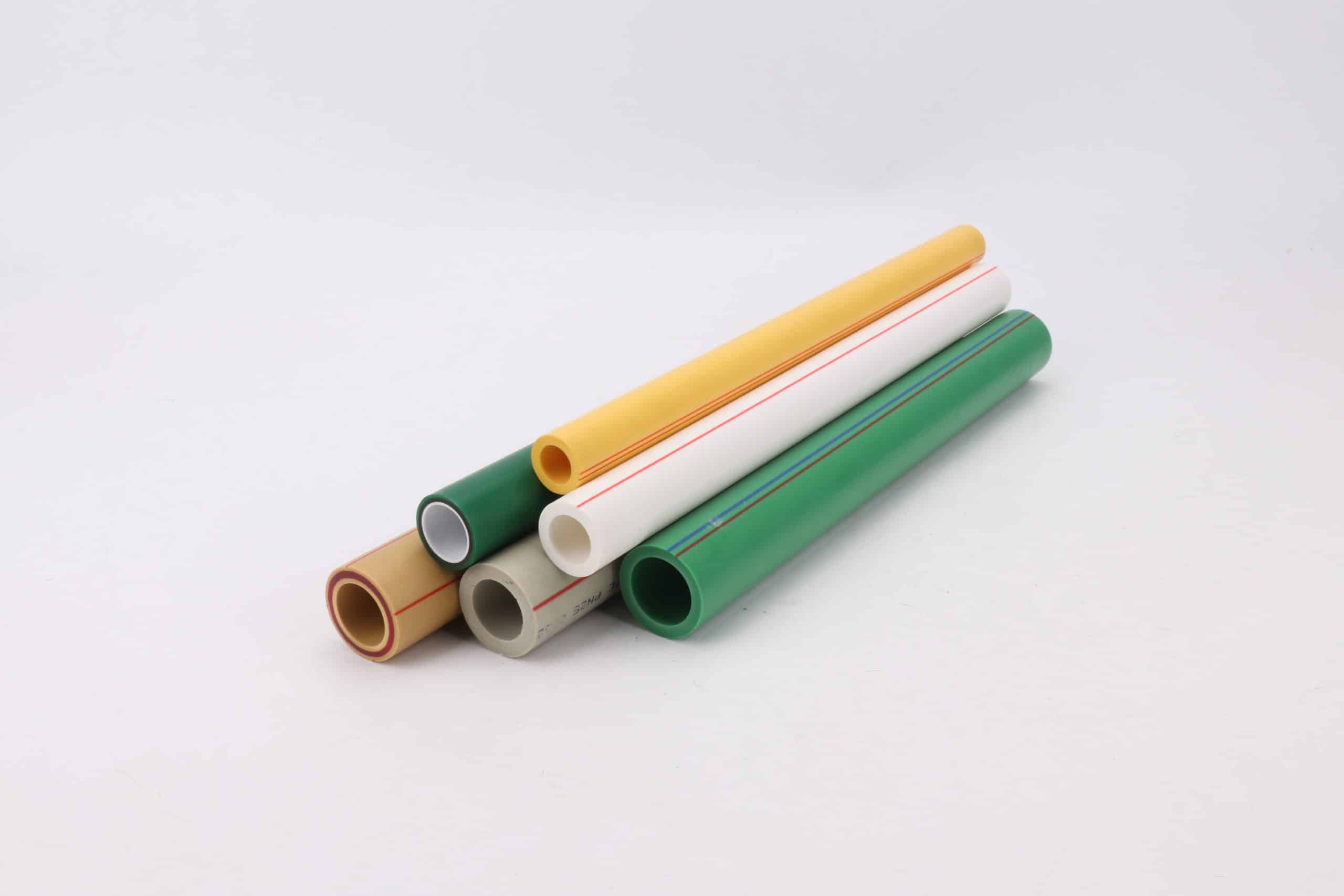 Cut ends of green, yellow, white, grey and tan polypropylene pipes stacked together, each showing its wall ring around the bore