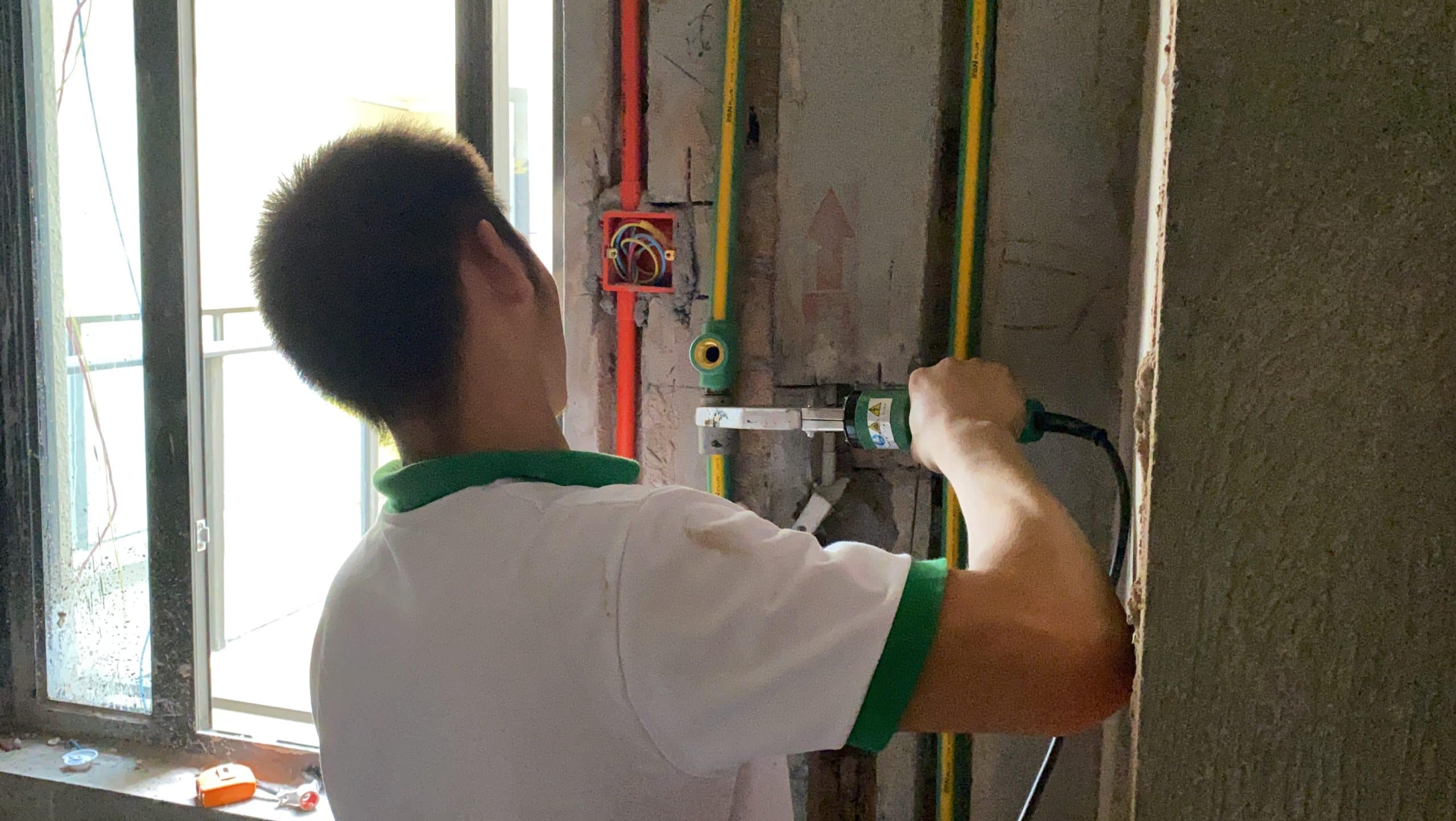IFANULTRA installer working with green PPR pipe and fittings on a renovation site