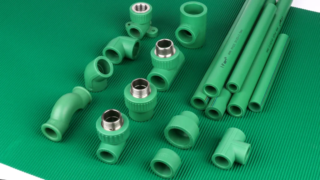 Green pipe sections and fittings arranged on a green background